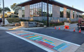 Crosswalk painting of books leading to library at the intersection of Clares street and Wharf Road